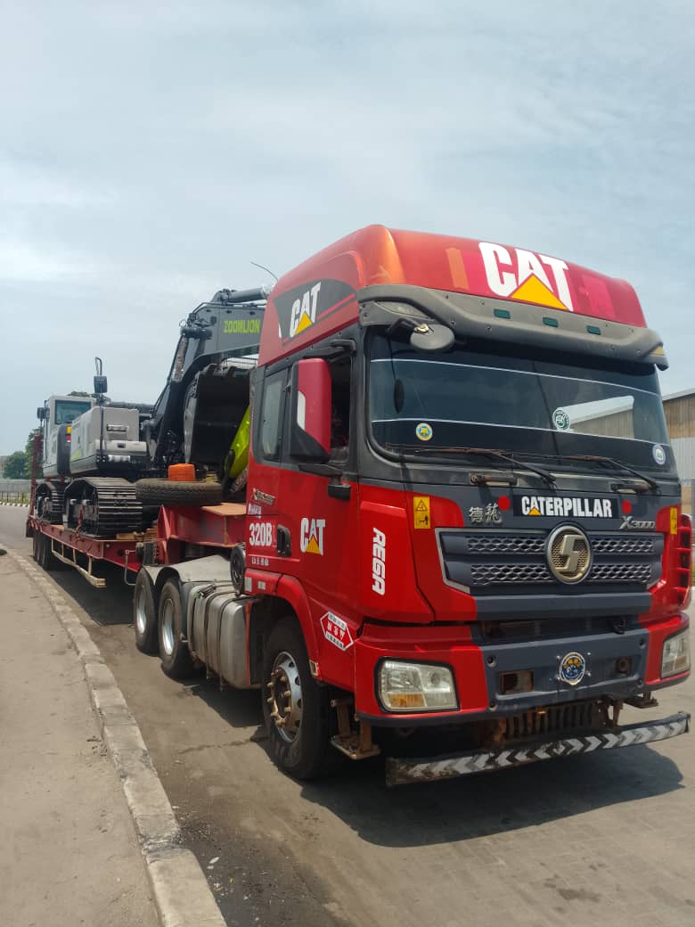 Heavy excavator loaded on a low-bed truck for transport